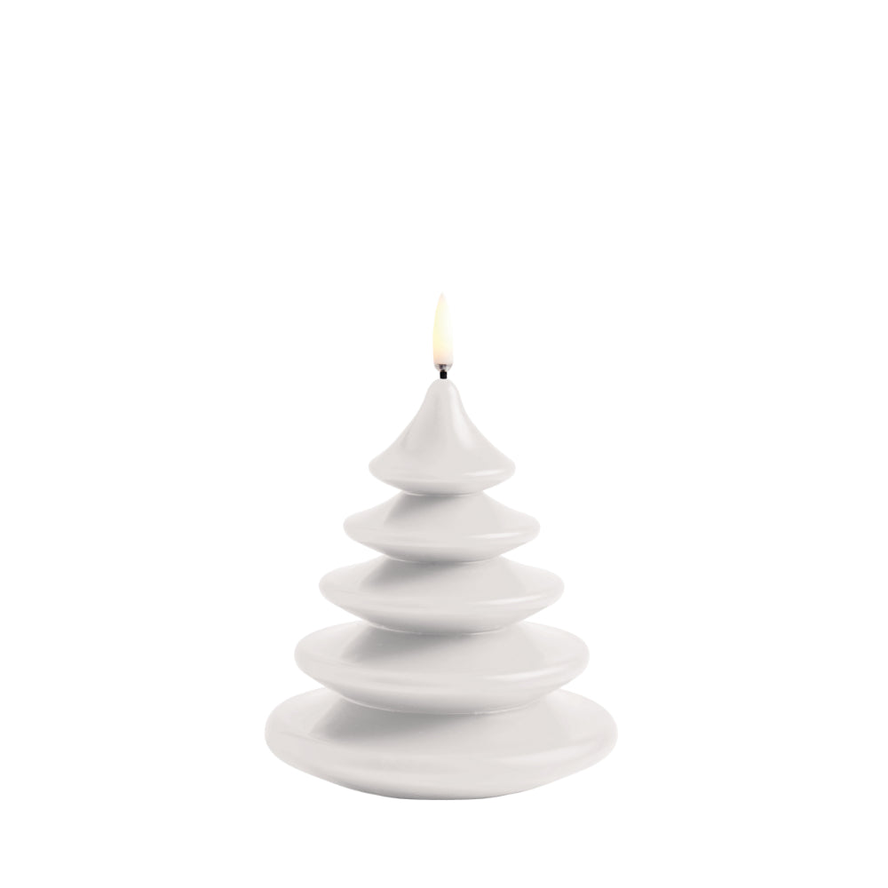 A white, tiered tree-shaped candle with a small flame at the top, centered on a plain white background.