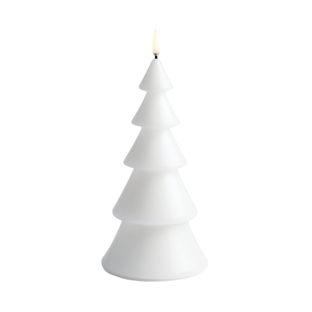 A white Christmas tree-shaped candle with a small glowing flame at the top, isolated on a white background.
