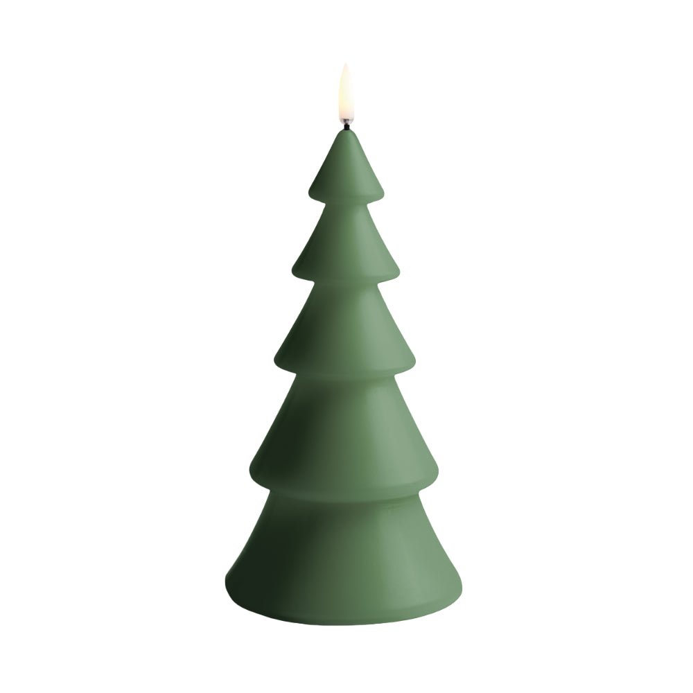 A tree-shaped candle in a matte forest green color, shown lit with a small flame on top, isolated on a white background.