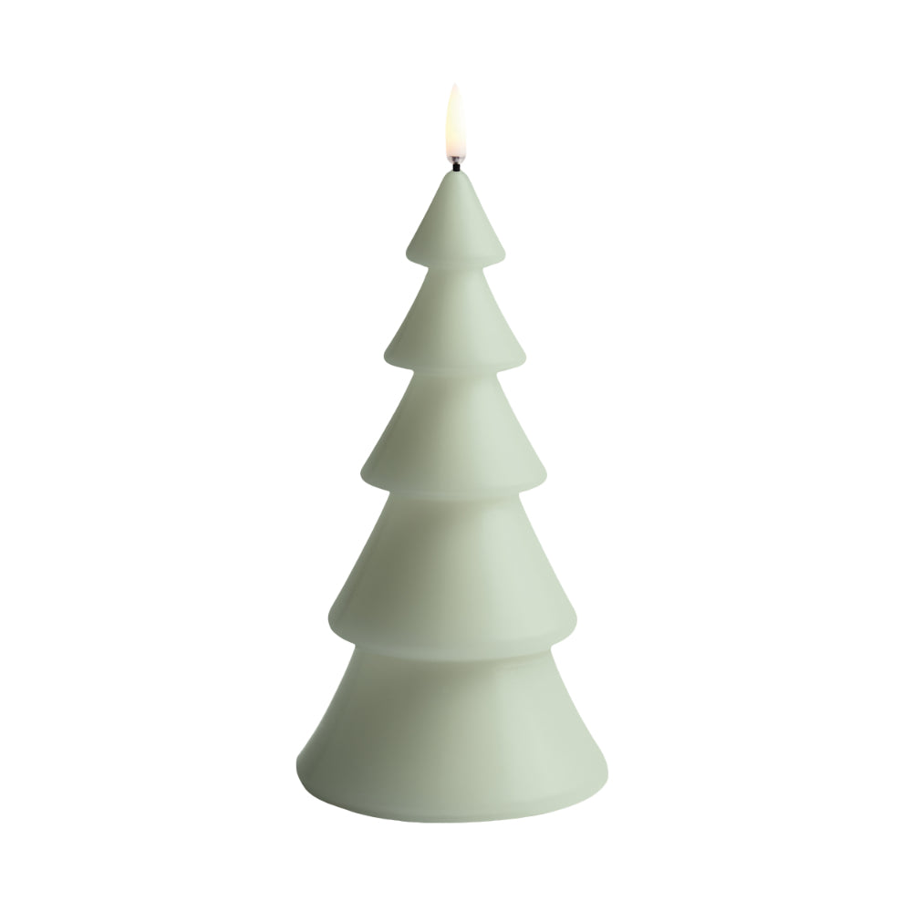 A tree-shaped candle in a pale sage green color, shown lit with a small flame on top, isolated on a white background.