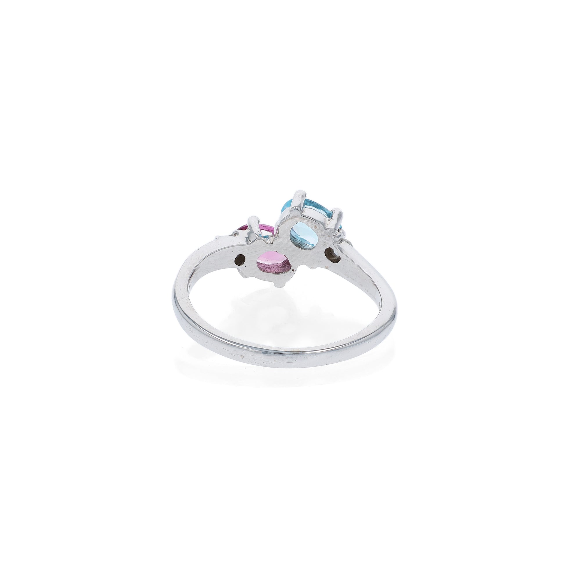 White gold ring with a blue topaz and  pink toumaline center and diamond sides on a white background