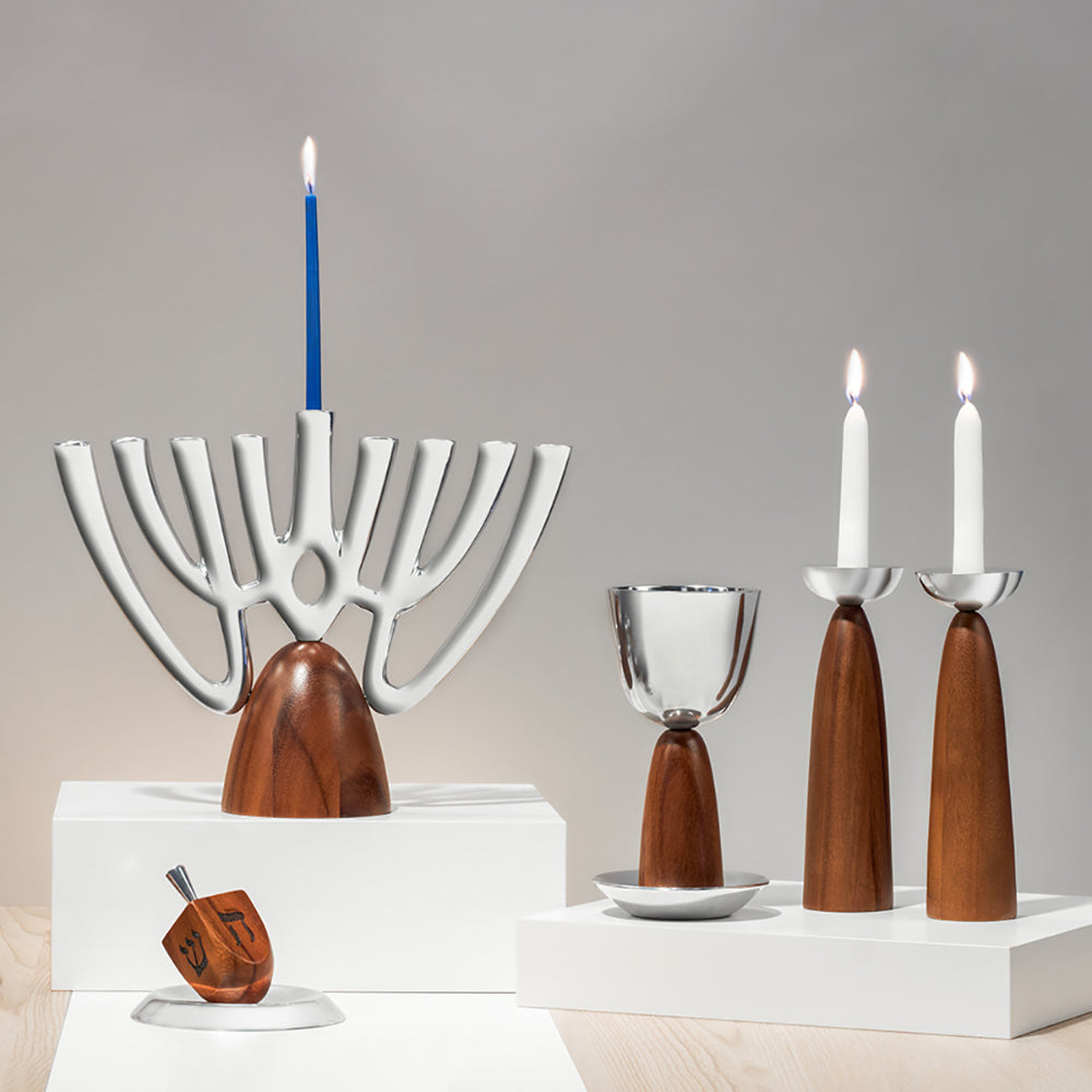 Decorative menorah with wooden base and glass candle holders on a neutral background