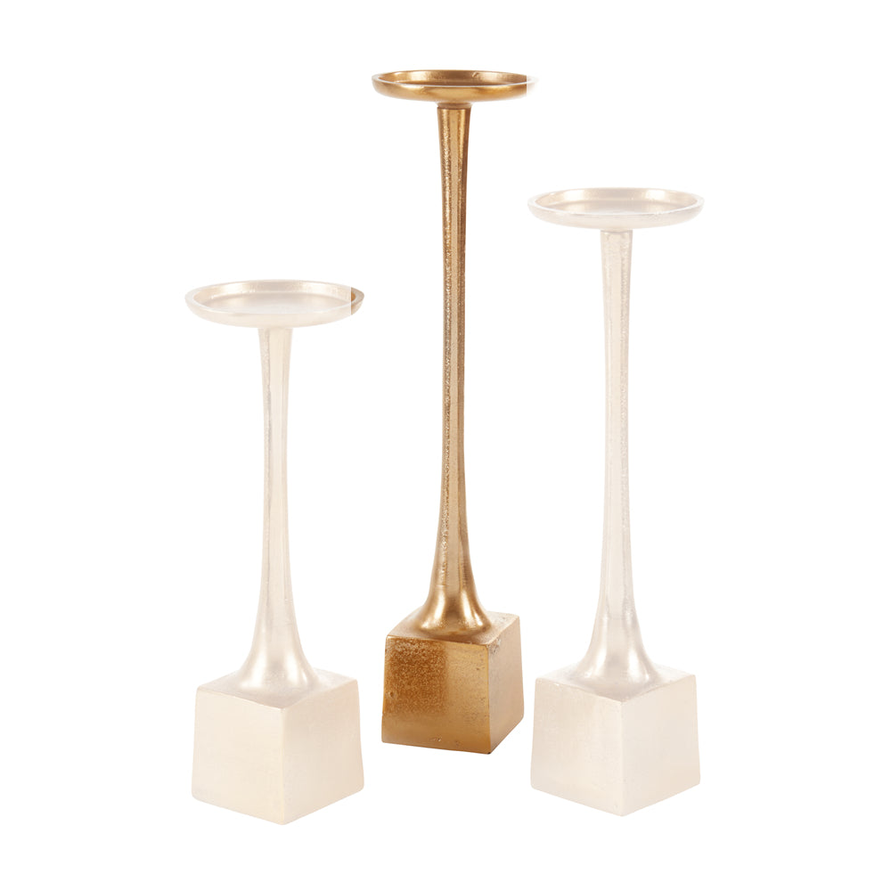 Three decorative candlesticks on a white background: one tall candlestick with a textured gold base and stem, and two shorter candlesticks with white bases and stems.