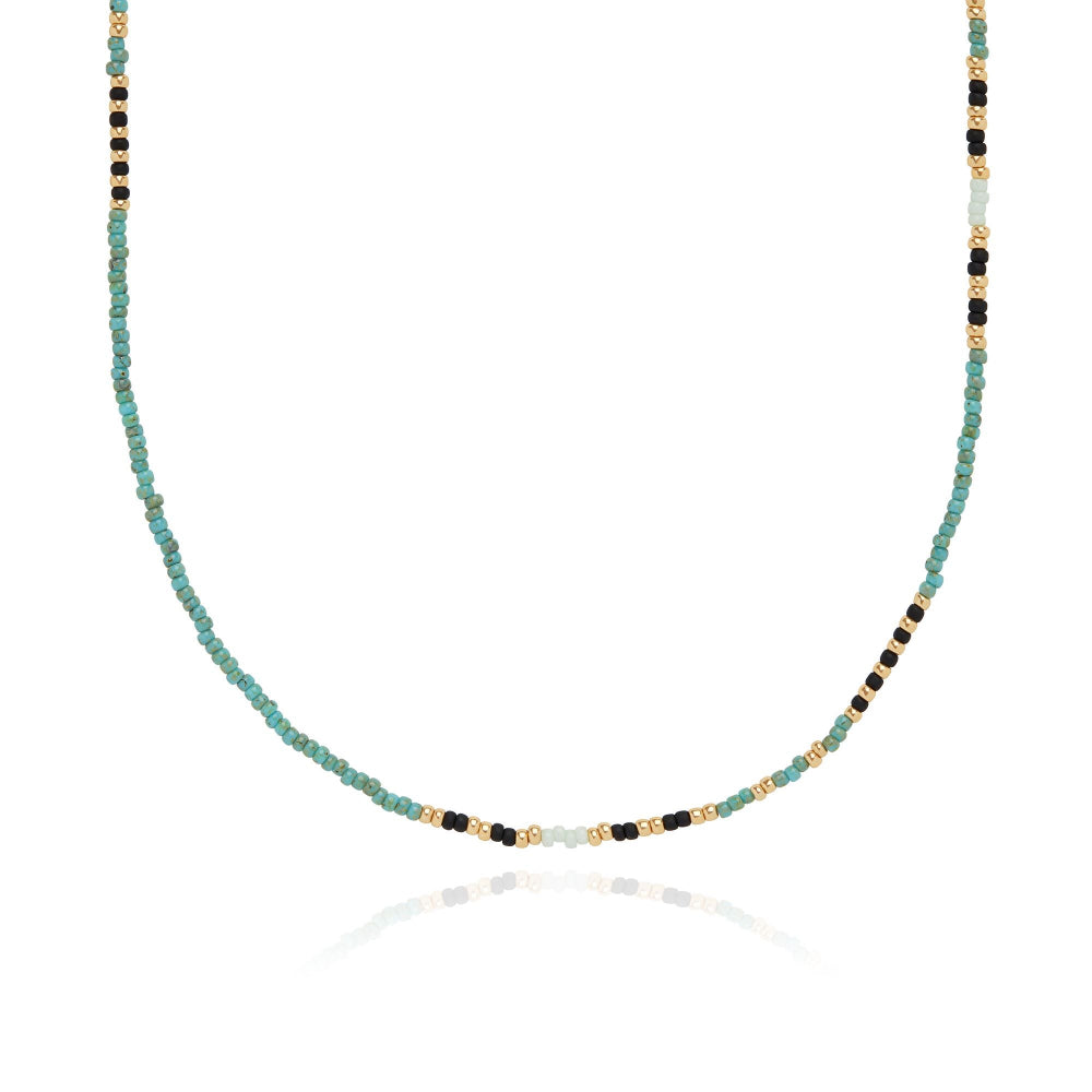 A beaded necklace with gold tone and multicolored beads, displayed against a white background.
