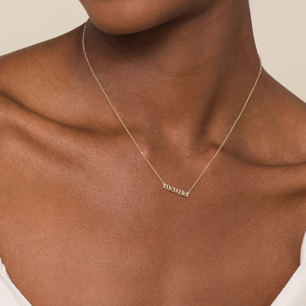 girl wearing gold mama pendant necklace on white background