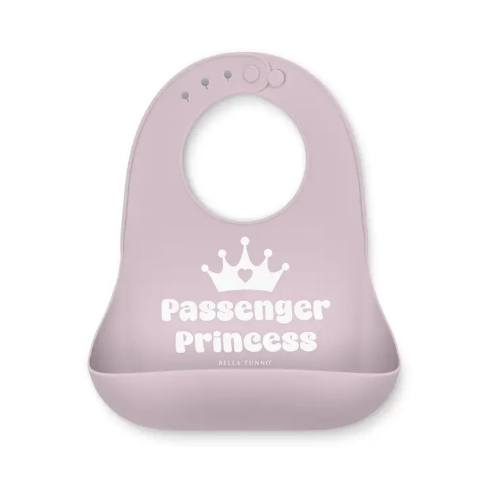 A light pink silicone baby bib with a white crown and 'Passenger Princess' text, shown on a plain white background.