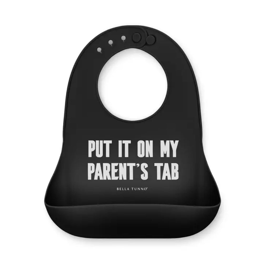 A black silicone baby bib with a white printed text design that reads 'PUT IT ON MY PARENT'S TAB' and the brand name 'BELLA TUNNO' underneath, shown on a plain white background.