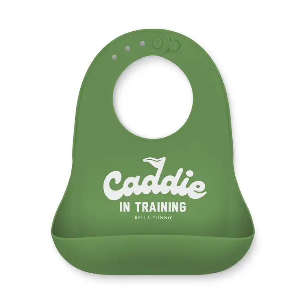 A green silicone baby bib with a white printed graphic reading 'Caddie IN TRAINING' and 'BELLA TUNNO', shown on a plain white background.