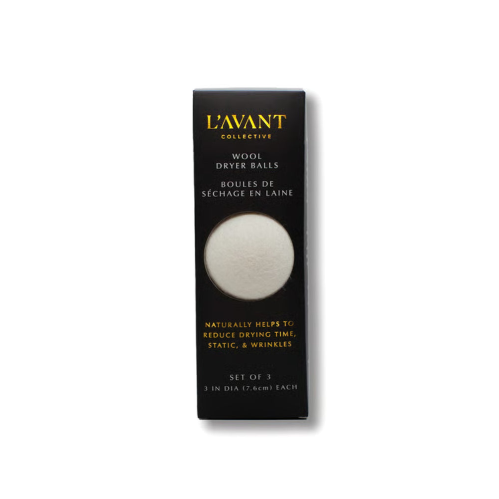 L'Avant Collective Wool Dryer Balls set of 3 in a black rectangular box with a circular cutout showing the white wool dryer balls inside, on a white background.