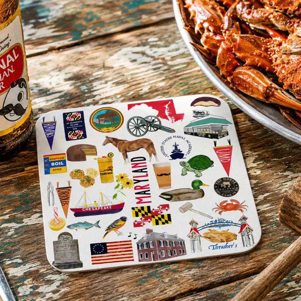 Coaster with Maryland-themed illustrations on a wooden table with a plate of crabs and a bottle of beer.