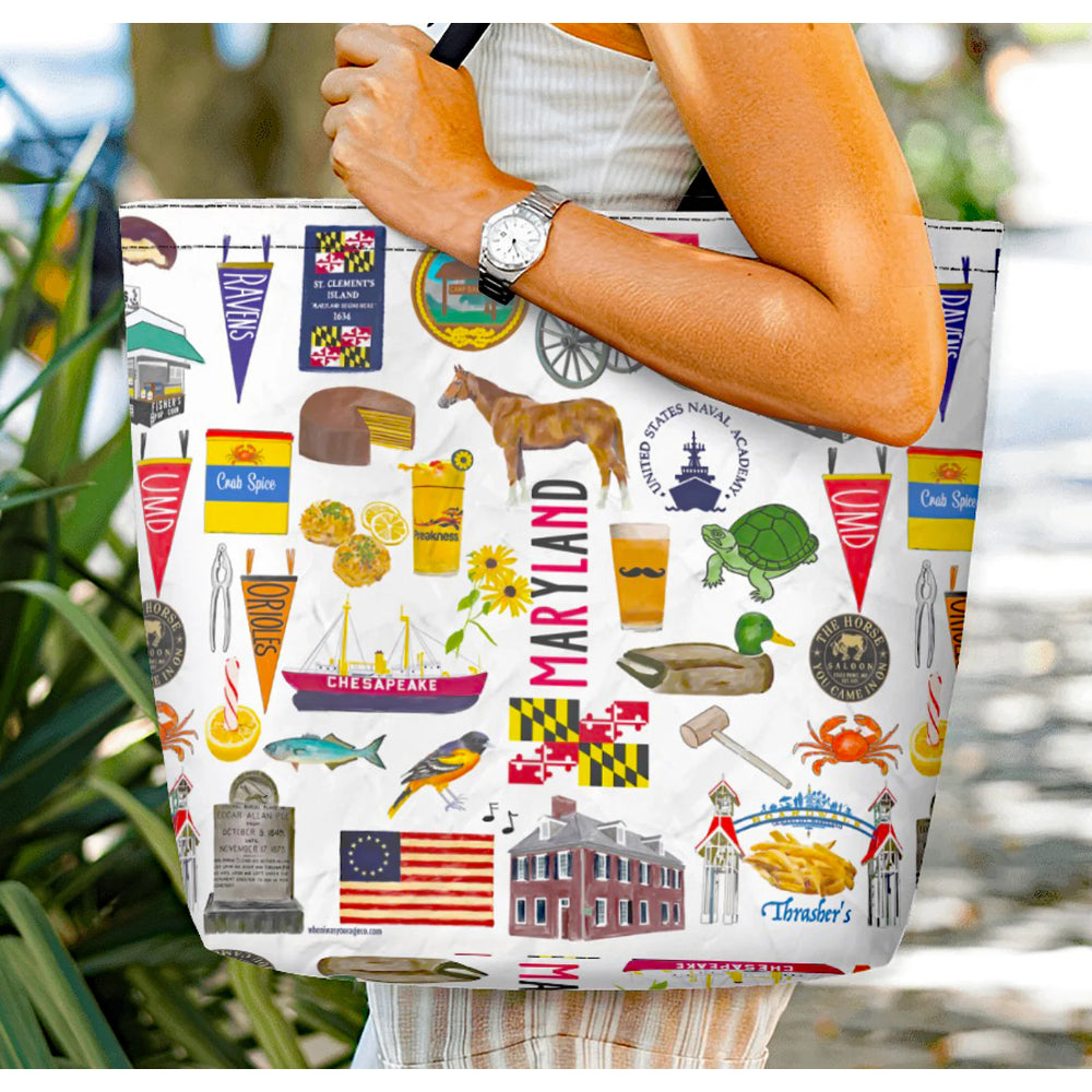 Tote bag with Maryland-themed design held by a person outdoors