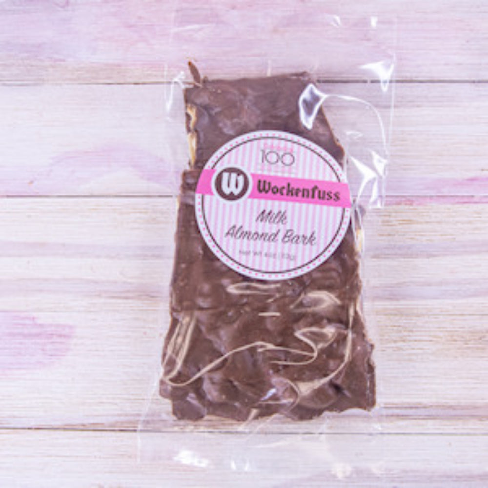 Packaged milk almond bark with Wockenfuss label on a wooden surface.
