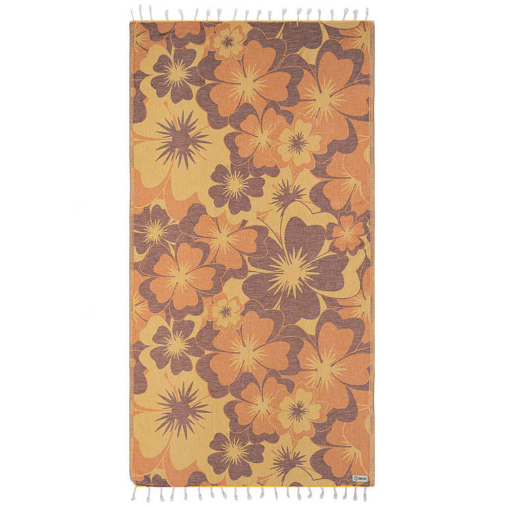 Side one of a floral patterned beach towel with orange and brown colors and a white tassel edge on a white background.