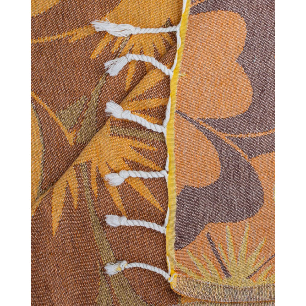 Close-up of a floral patterned beach towel with orange and brown colors and a white tassel edge on a white background.