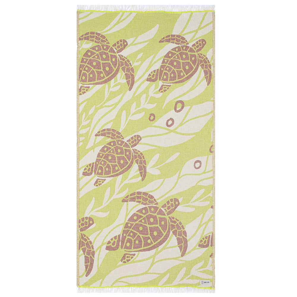 Side one of a beach towel with a yellow and brown sea turtle pattern a white tassel edge on a white background.