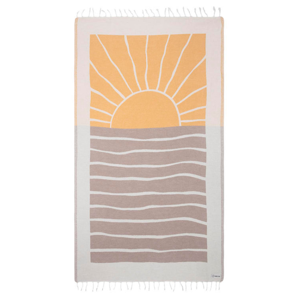 A beach towel with a yellow, brown and white sun and wave design with a white tassel edge on a white background.