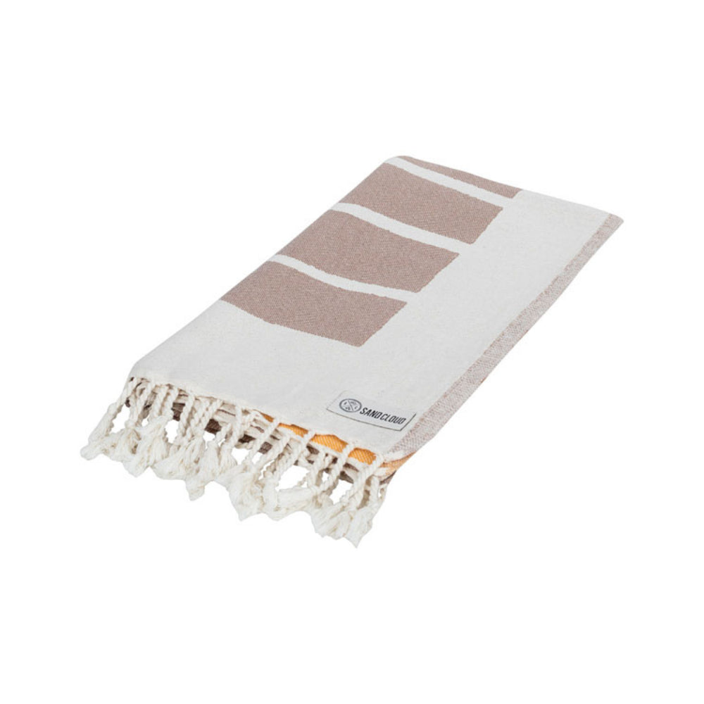 A folded beach towel with a yellow, brown and white sun and wave design with a white tassel edge on a white background.