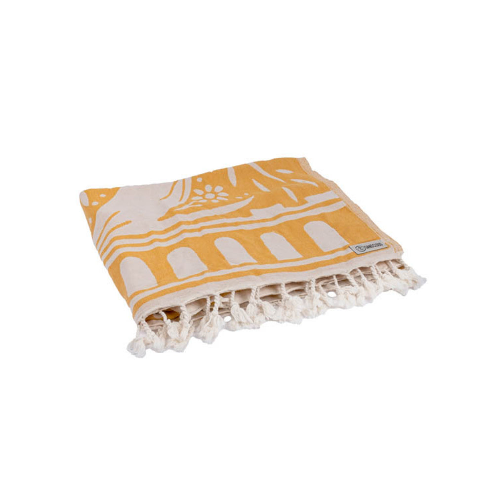 Folded yellow and white reversible patterned beach towel with white tassel edge on a white background.