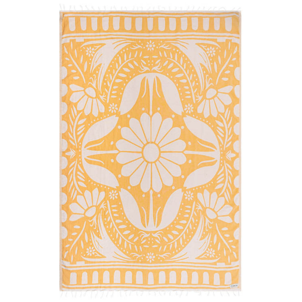 Side one of a yellow and white reversible patterned beach towel with a white floral design on a yellow base with a white tassel edge on a white background.