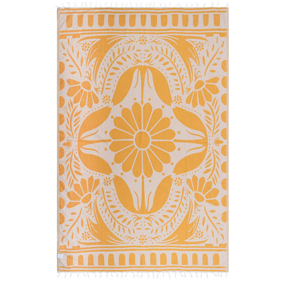 Side two of a yellow and white reversible patterned beach towel with a yellow floral design on a white base with a white tassel edge on a white background.