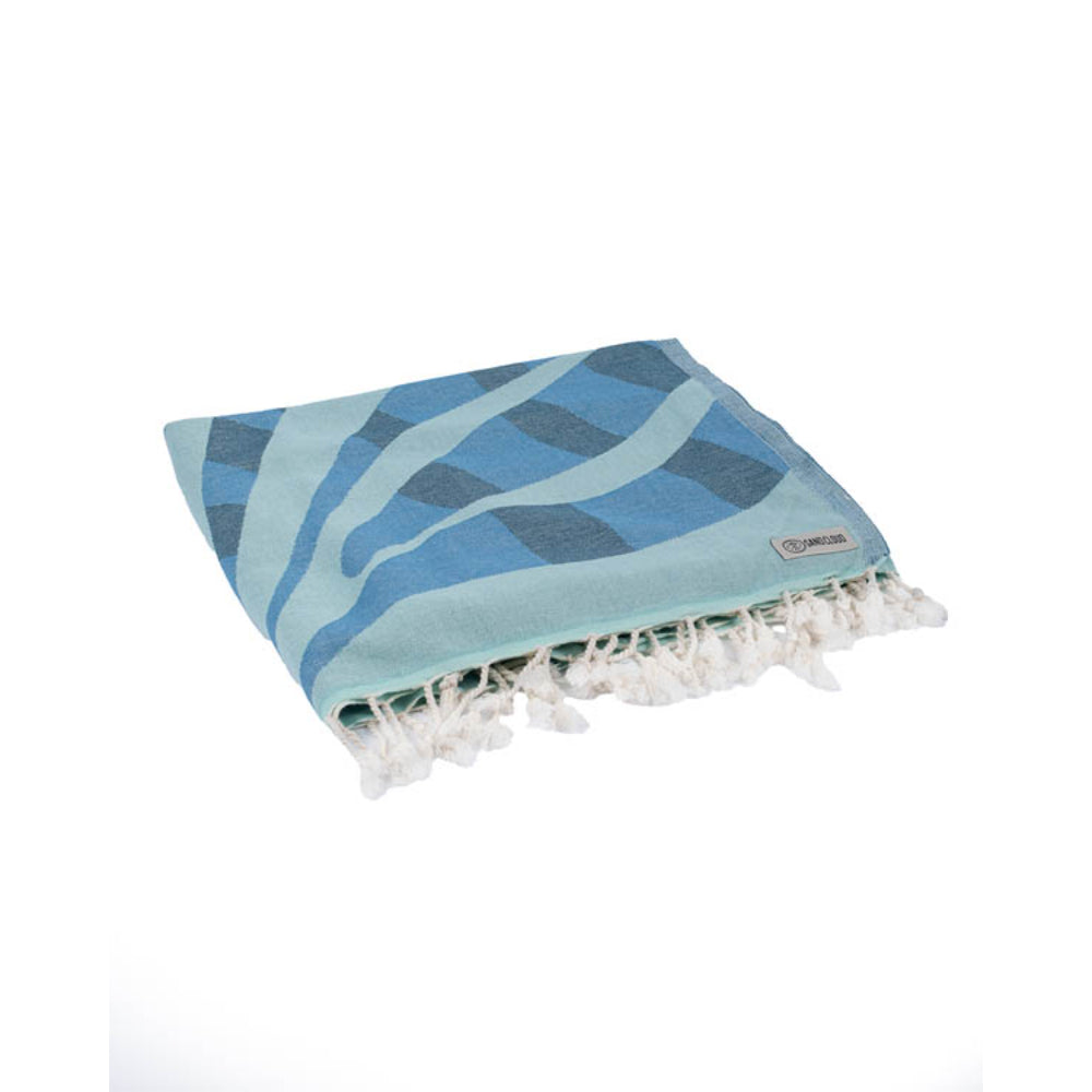 Folded blue beach towel with two reversible patterns with a seal design and blue wavy patterns on a white background.