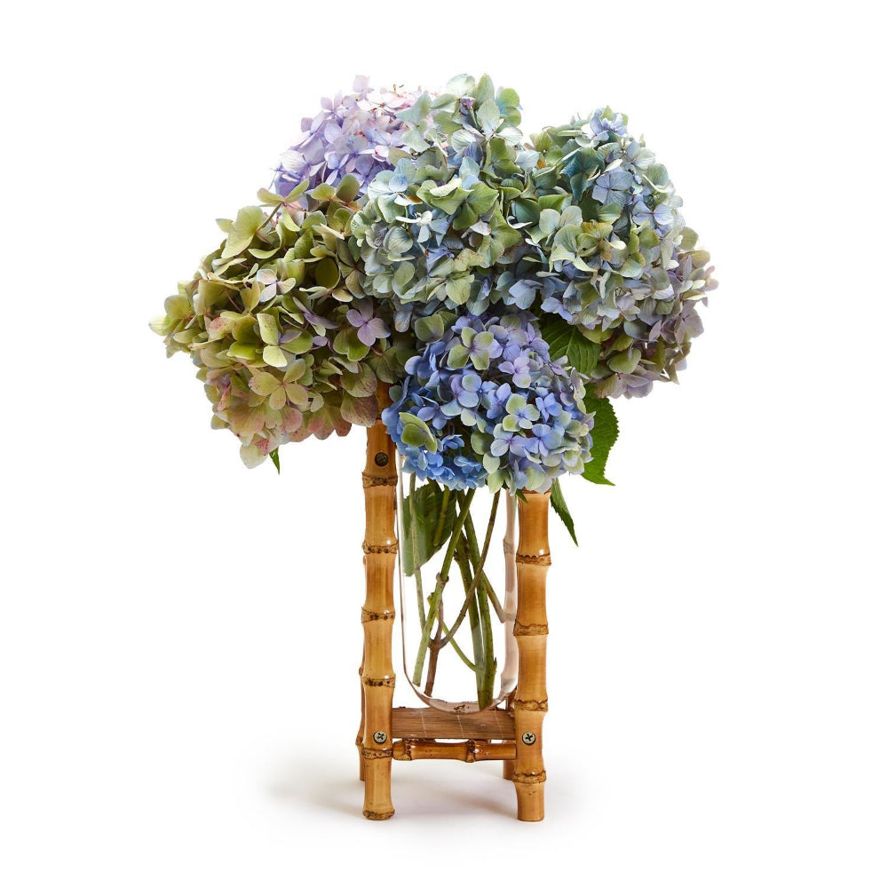 Bouquet of hydrangeas in a bamboo vase on a white background.