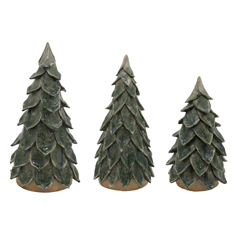Three small pine tree-shaped decorative objects with a textured, weathered green finish and tan bases, arranged from left to right in varying heights on a plain white background.