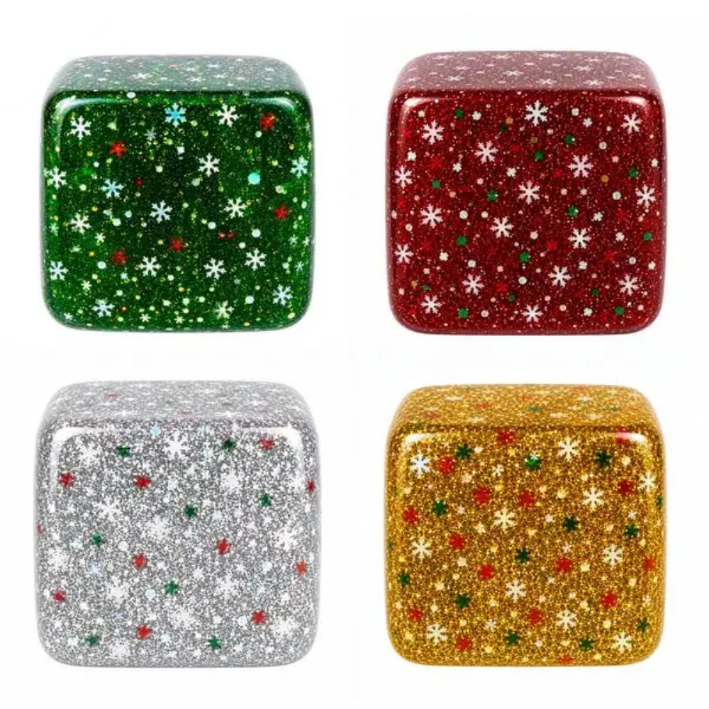 Four square glittery decorative cubes arranged in a 2x2 grid on a white background, each with a holiday snowflake pattern: green with white and small red/blue accents, red with white snowflakes, silver with white and small red/green accents, and gold with white and small red/green accents.