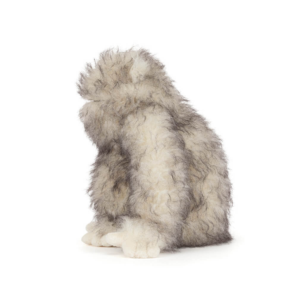 A side photo of a plush toy Bretti Yeti with gray and white fur on a white background.