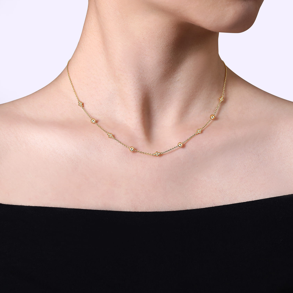 Gold necklace on a model against a plain background