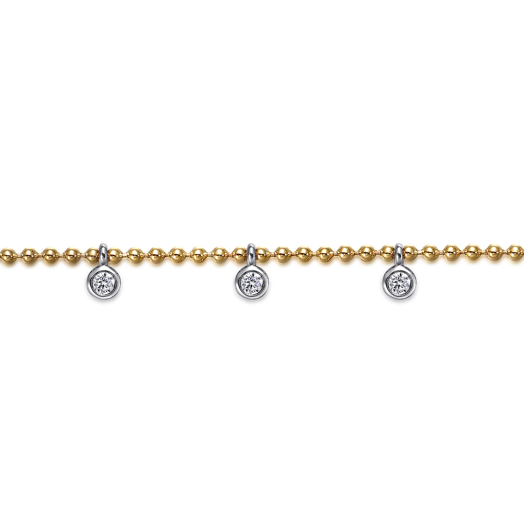 gold bracelet with white and silver droplets on white background