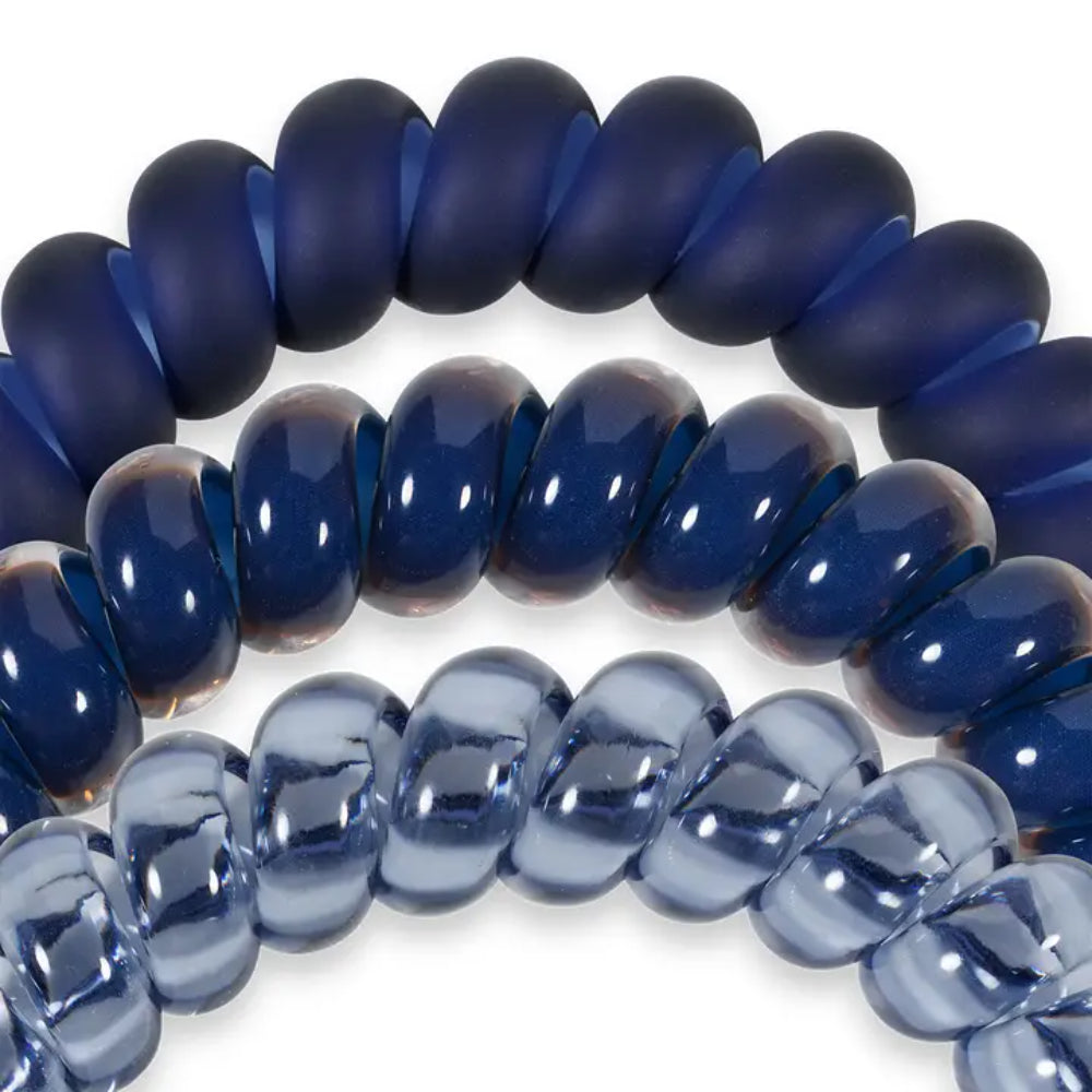 Close-up of blue coil hair ties on a white background