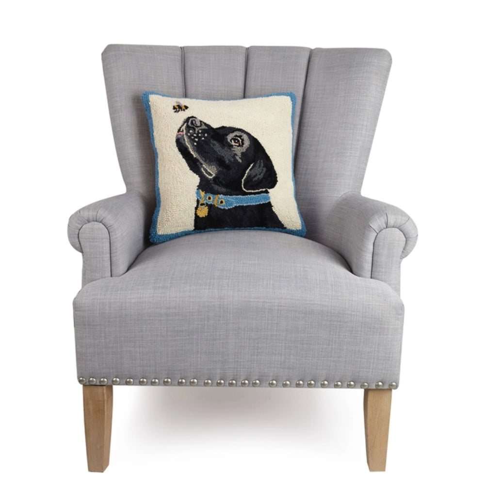 Gray armchair with a decorative pillow featuring a black dog design on a white background
