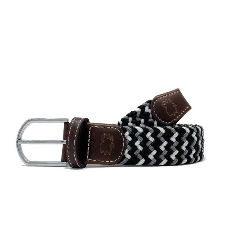 Black and white woven belt with brown leather strap and silver buckle on a white background