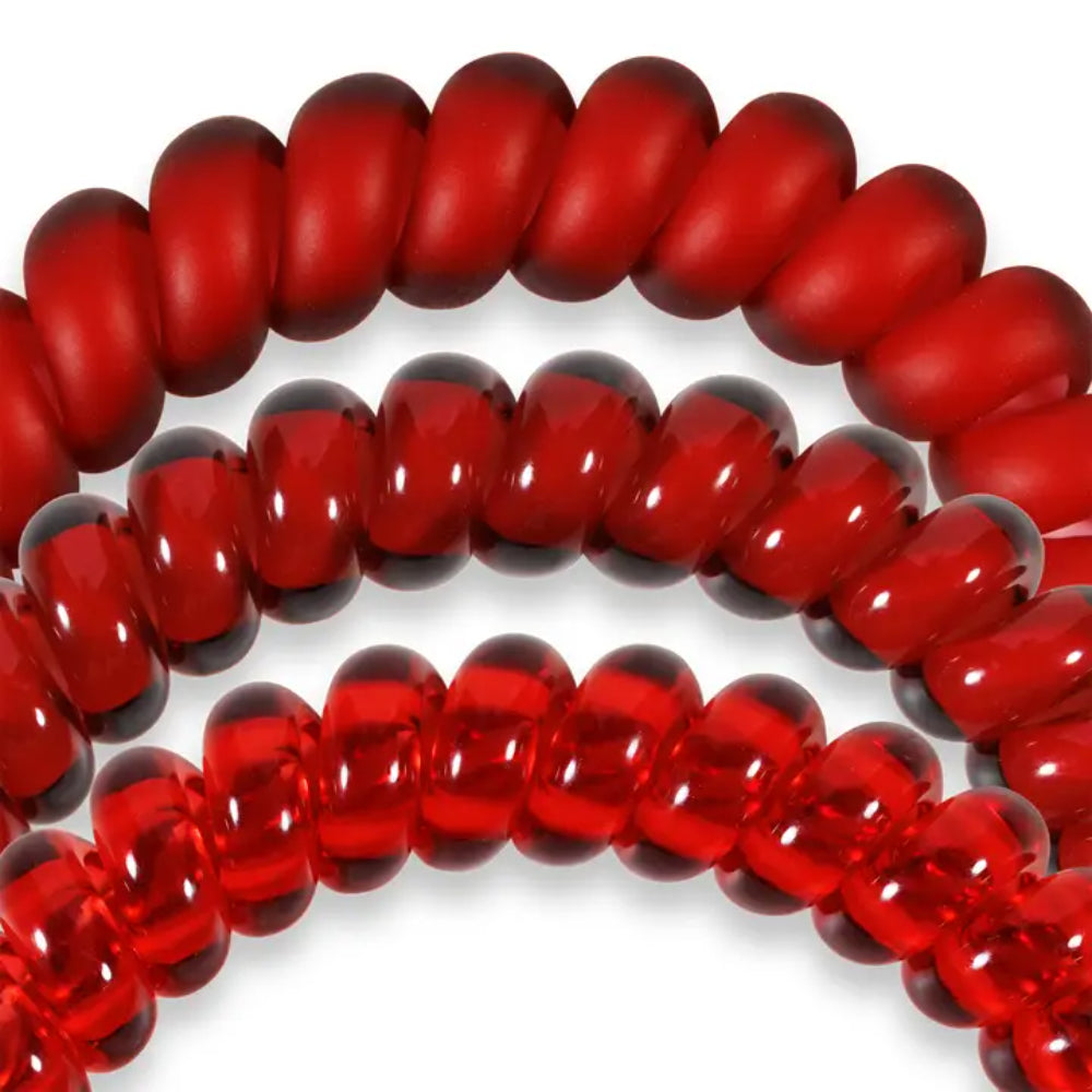 Close-up of red hair ties on a white background