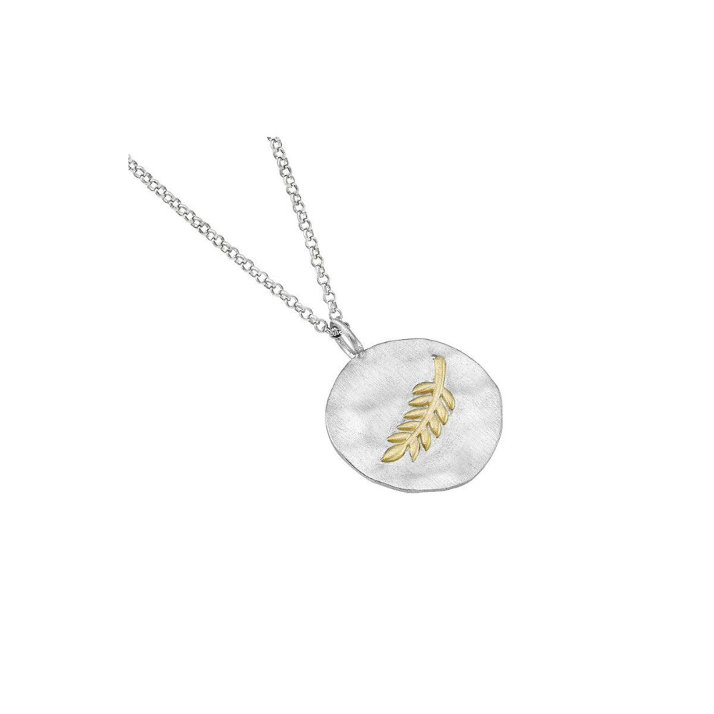 silver round disc pendant with gold detail on a silver chain on a white background