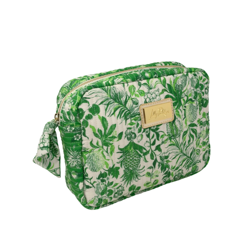 A green and white tropical pineapple print toiletry bag with a gold-tone zipper and a small gold brand plaque on the front.