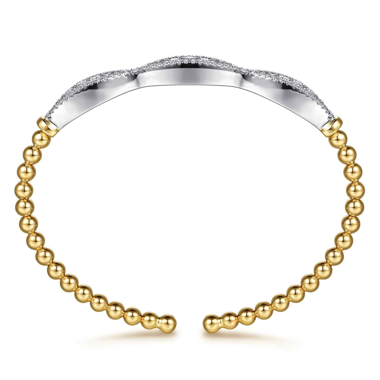 A two-tone open cuff bracelet featuring a polished yellow gold beaded lower section and a silver-toned top band paved with small clear stones, shown on a white background.