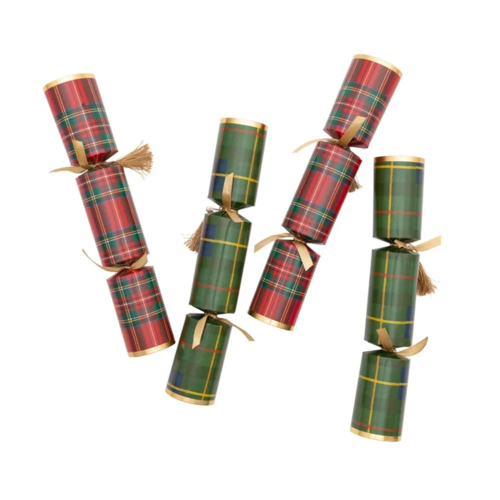 Four Christmas cracker ornaments wrapped in festive tartan plaid paper, featuring red, green, and gold patterns with gold ribbon ties and tassels, arranged on a plain white background.