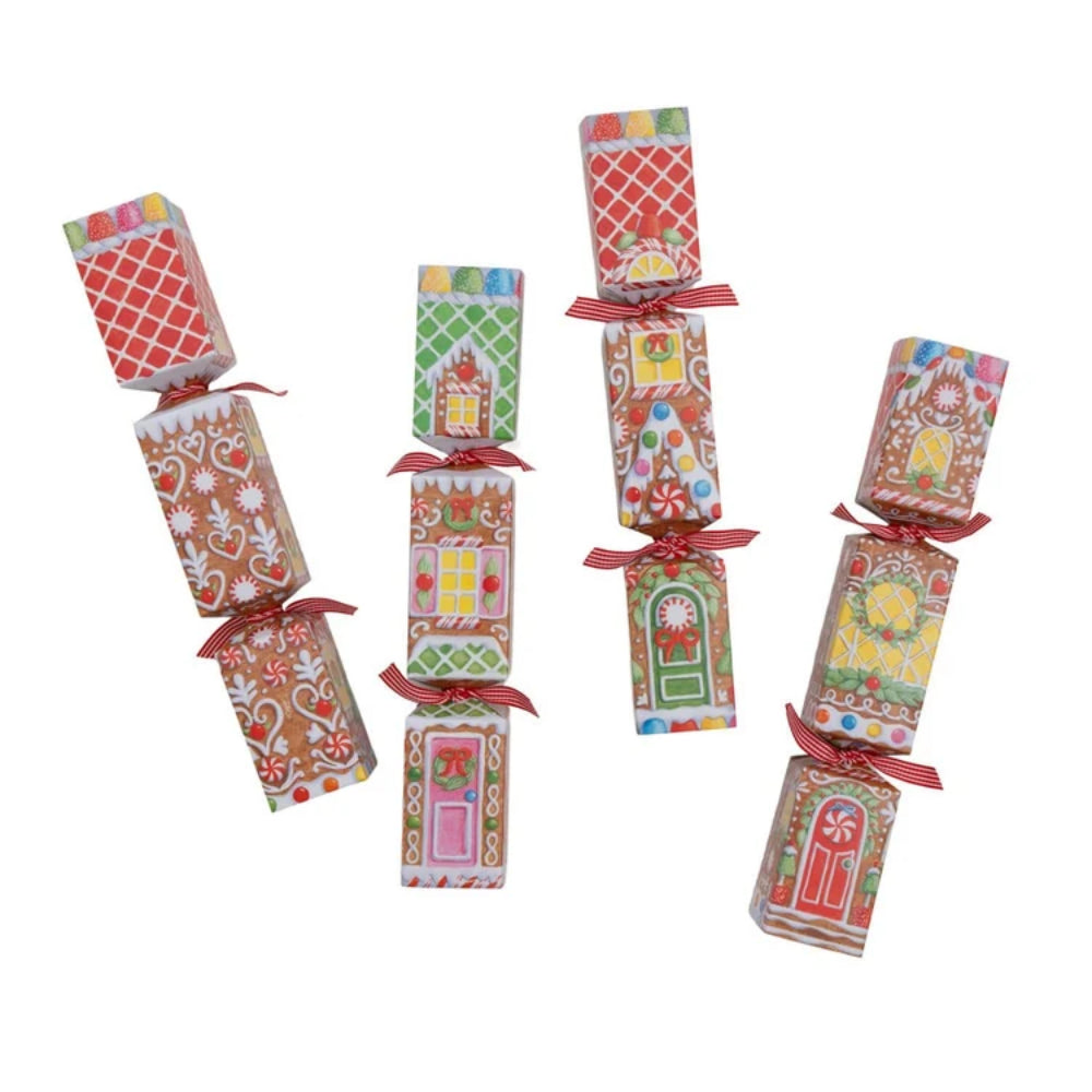 Six Christmas-themed paper gift boxes or crackers with gingerbread house patterns, tied with red ribbons, arranged on a plain white background.