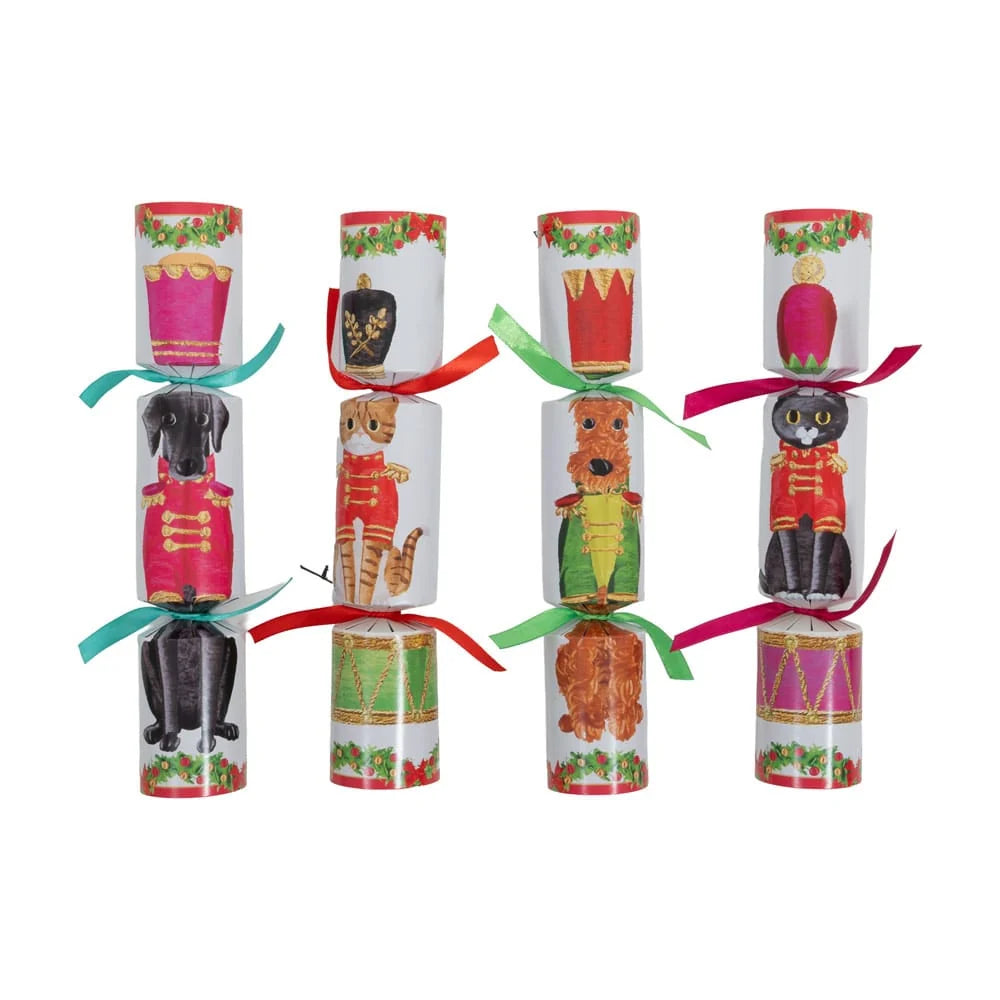 Christmas-themed cylindrical crackers arranged in two columns of four on a plain white background. Each cracker features a different festive animal illustration, including dogs, cats, a tiger, a bear, and a horse, with colorful ribbons tied at the top and bottom.