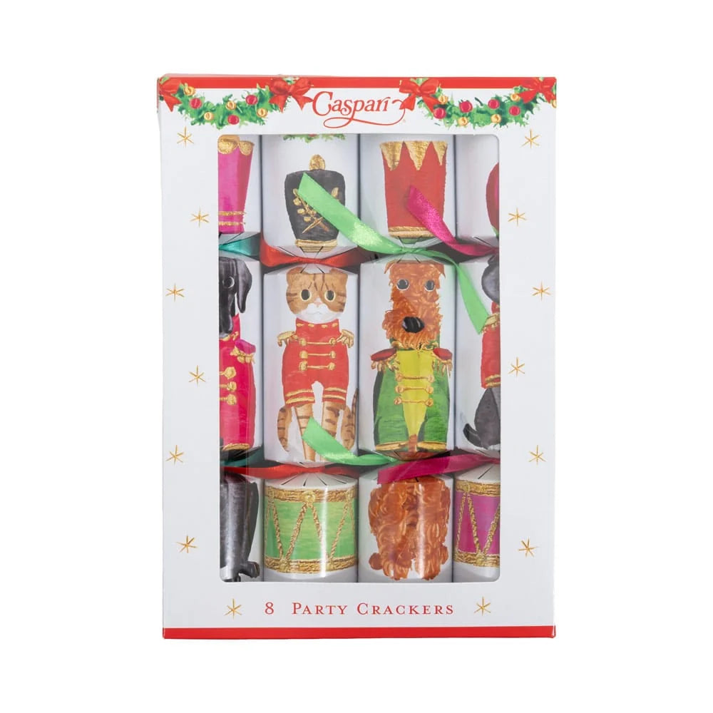 A boxed set of 8 Caspani party crackers featuring festive Christmas nutcracker and drum illustrations, presented in a white window box with red trim and gold star accents.