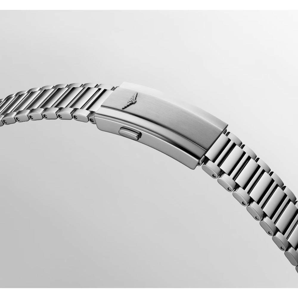 Close-up of a silver stainless steel watch band clasp with a wing logo, shown on a light gray background.
