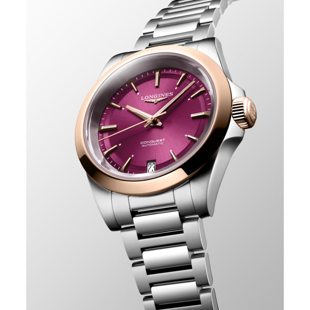 Silver watch with a pink face on a light gray background