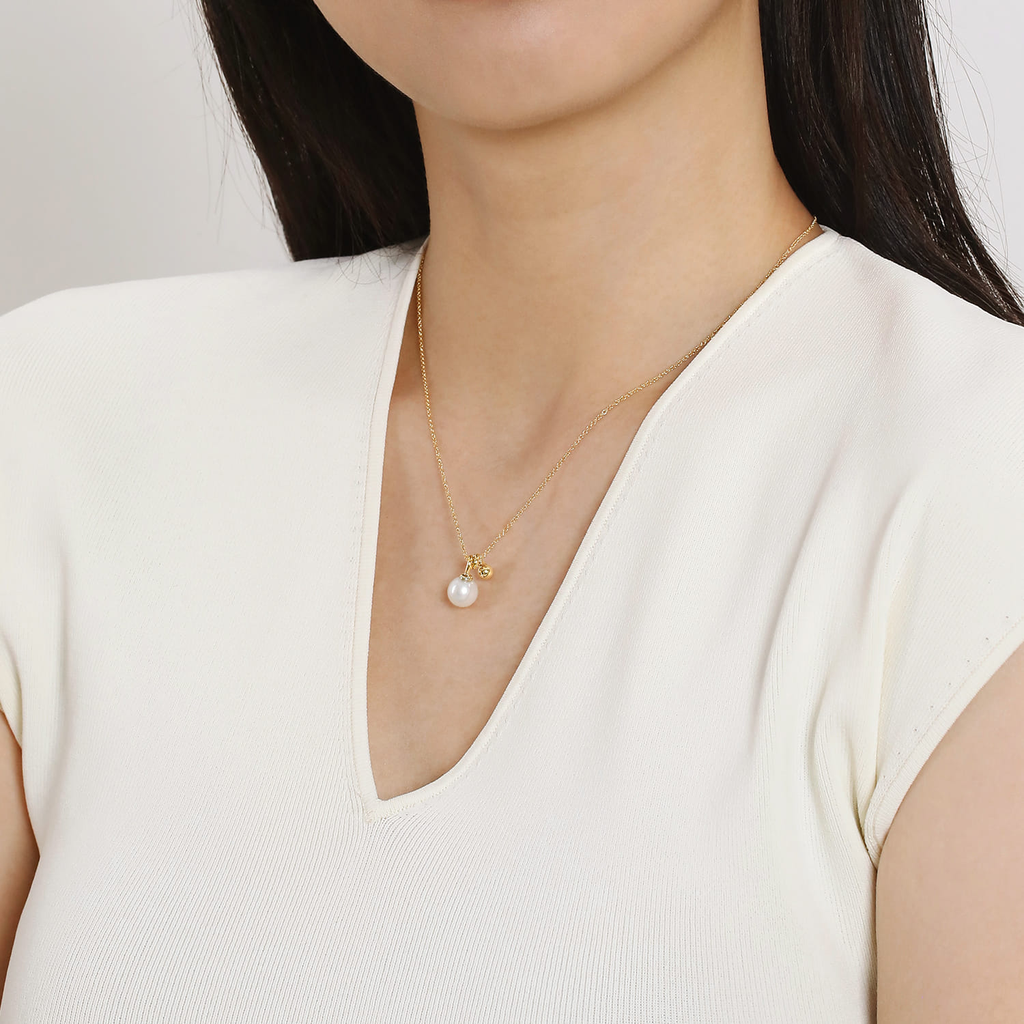 model wearing Pearl pendant on yellow gold chain on natural background