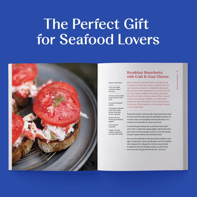 Open cookbook showing a recipe for Breakfast Bruschetta with Crab & Goat Cheese, on a blue background with text 'The Perfect Gift for Seafood Lovers'.