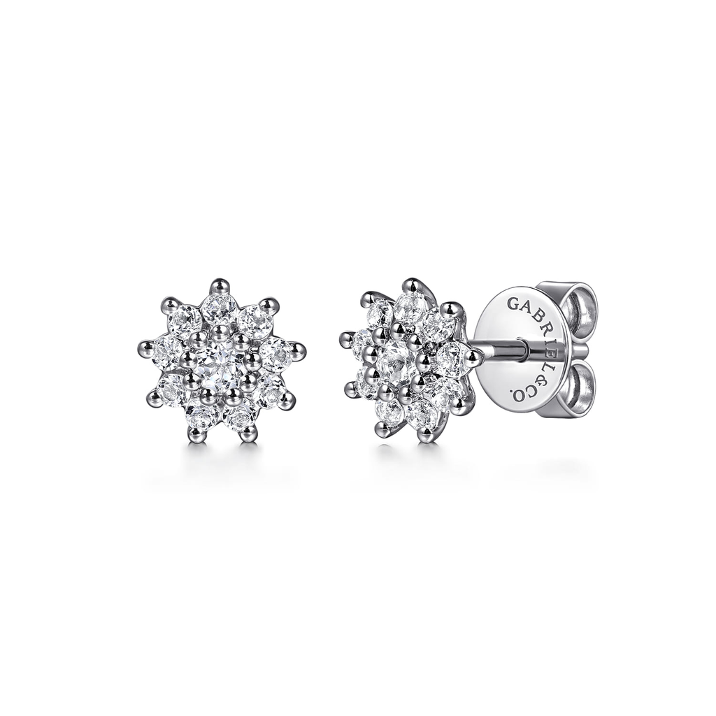 Pair of silver flower-shaped earrings with clear gemstones on a white background