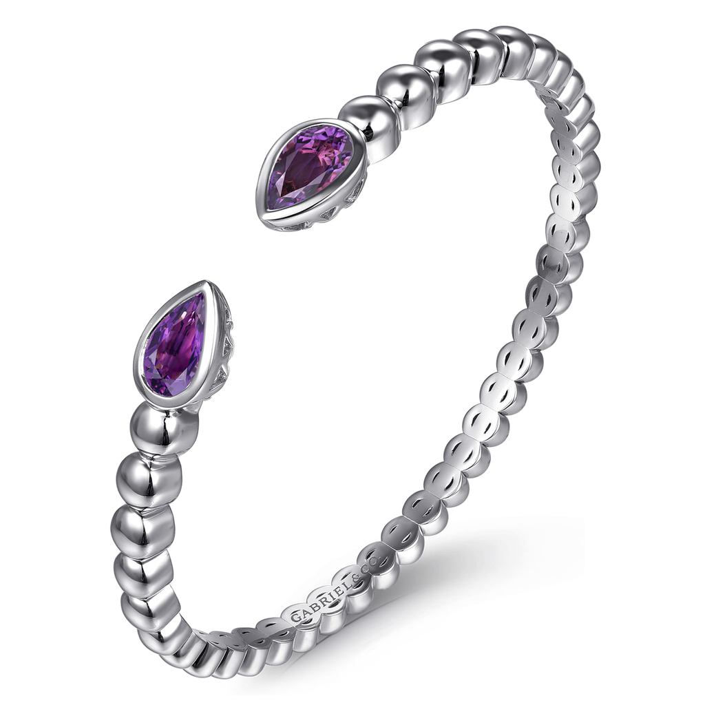 Silver ring with purple gemstones on a white background