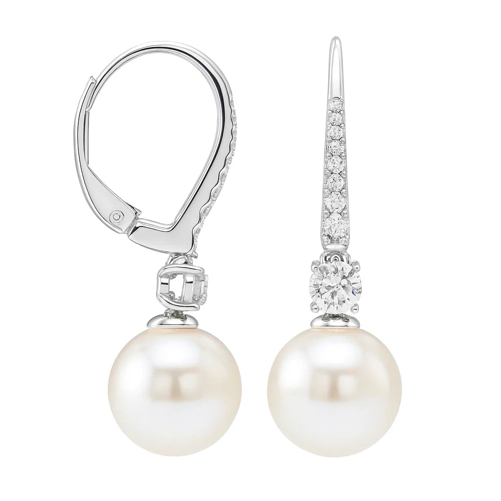 A pair of silver leverback earrings featuring a large white freshwater pearl and a diamond-accented spade-shaped setting, shown on a solid white background.
