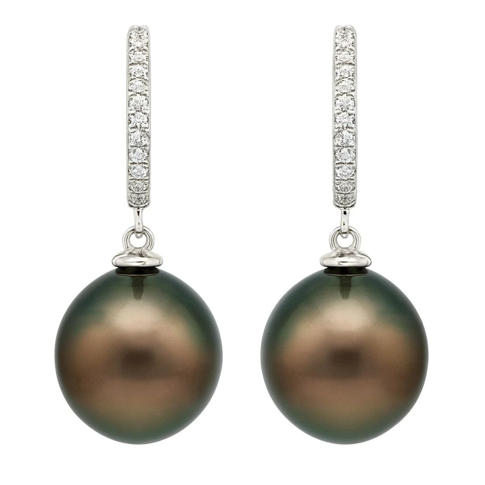 A pair of drop earrings featuring large oval dark green-black pearls suspended from silver-toned hoops paved with small clear stones, shown on a plain white background.